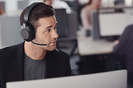Man wearing black Evolve2 85 headphones taking a call