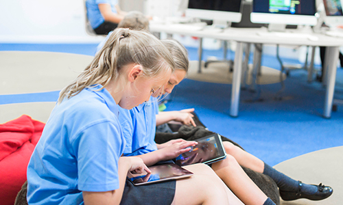Three mid school students using Windows 10 devices