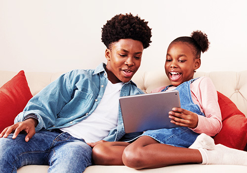 Siblings sharing iPad at home