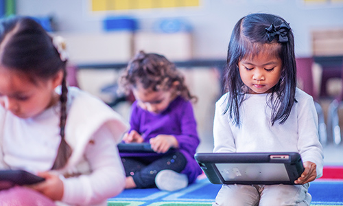 Girls in a classroom using mobile devices