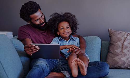 Parent and child using mobile device at home 