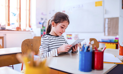 Female student using mobile device in classroom