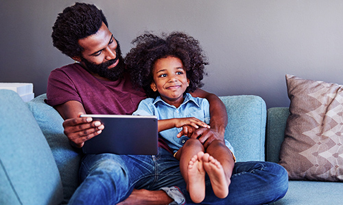 Parent and child using mobile device at home