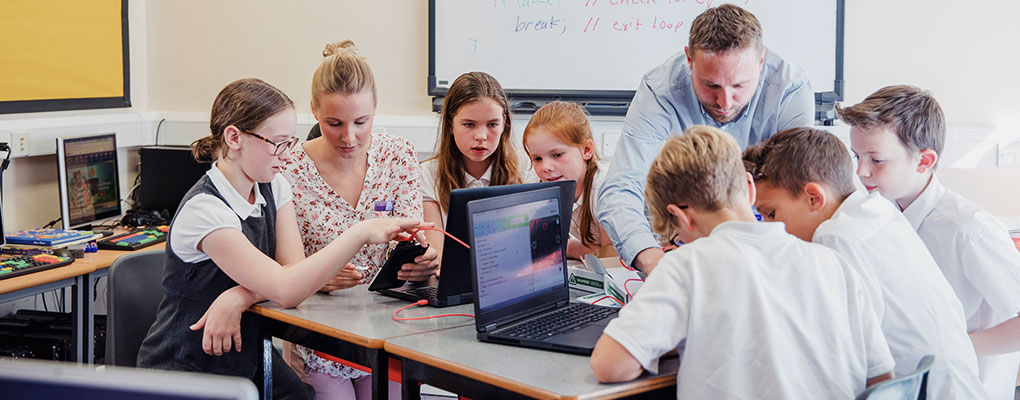 Teachers coaching students through coding